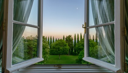 Fototapeta premium Open Window Looking Out to a Lush Green Garden and Cypress Trees at Sunset