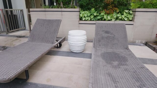Two comfortable sun loungers and a white side table by the outdoor patio area.