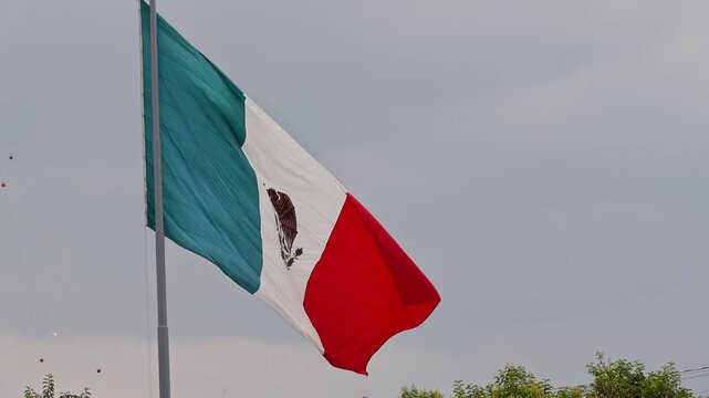 Large Mexican Flag Waving Against Overcast Sky Mexico City Zocalo