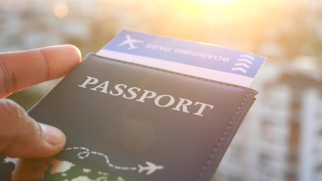 Person holding passport and boarding pass with sun flare in background, ready for travel