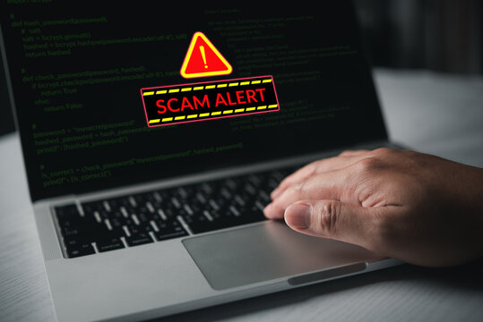 Scam Alert on Laptop Screen with Warning Sign and Code for Online Fraud Phishing Cybersecurity Risk and Digital Threat Awareness