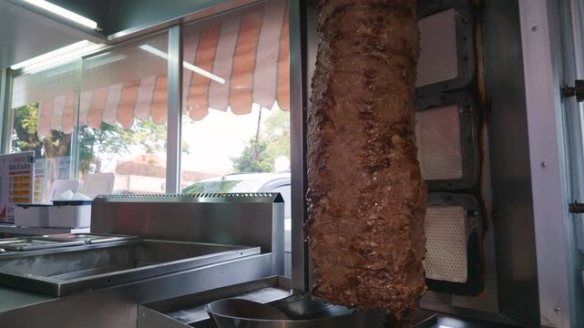 Traditional Meat Skewer Roasting on a Vertical Spit in a Street Food Restaurant.