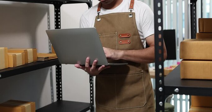 Small business owner managing packaging, inventory and order fulfillment in a modern workspace, representing e-commerce, warehouse organization, shipping and efficient business operations.