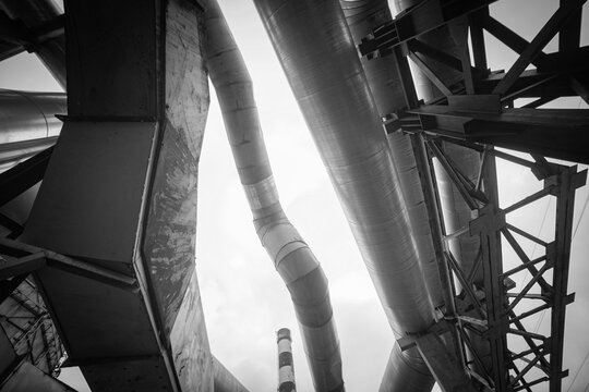 Heavy industrial pipes and factory smokestack monochrome geometric background with copy space