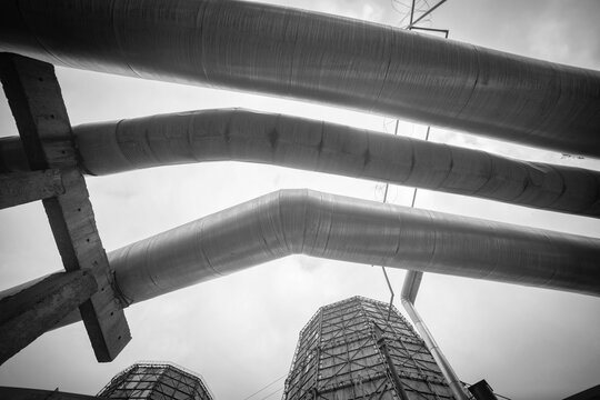 Black and white industrial pipes and cooling towers abstract background with copy space