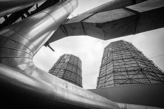Industrial power plant metal pipes and cooling towers monochrome abstract frame with copy space