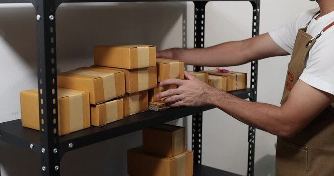 Small business owner managing packaging, inventory and order fulfillment in a modern workspace, representing e-commerce, warehouse organization, shipping and efficient business operations.