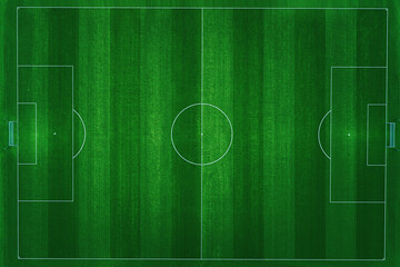 Aerial top-down view of a professional football field with vibrant green grass and clear white markings. The pitch is empty, perfectly manicured, and ready for a soccer match in a stadium at night. © Qasim