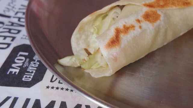 Fresh vegetable tortilla wrap roll served on a plate for lunch.