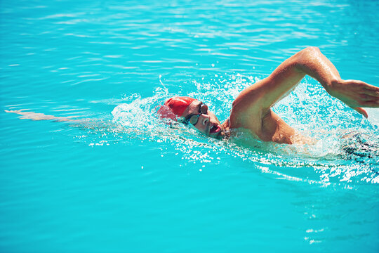 Fitness, man and swimming in pool for workout, exercise and aquatic practice for body wellness. Male person, swimmer and training for water sports, freestyle stroke and healthy lifestyle in summer