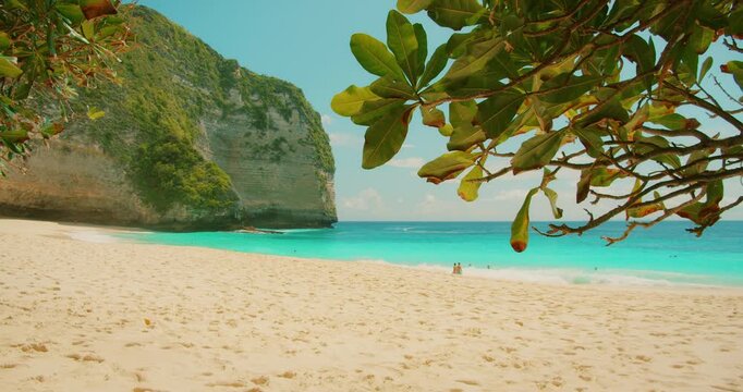 Natural tropical beach with white sand and turquoise ocean waves in Nusa Penida