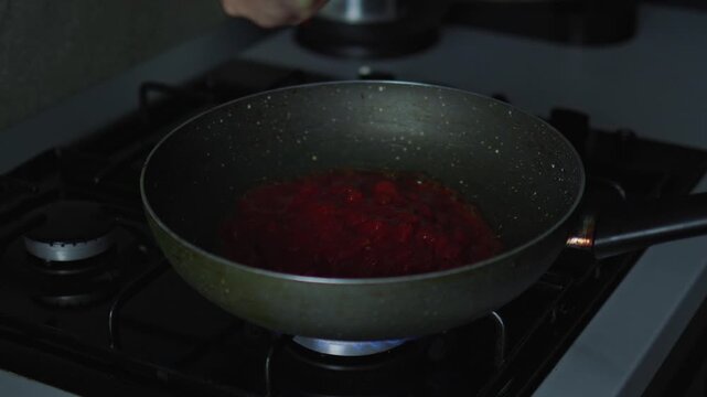 Cooking shakshuka, pouring tomatoes in a pan, and grating cheese. Homemade meal preparation, culinary recipe, and kitchen cooking process concept.