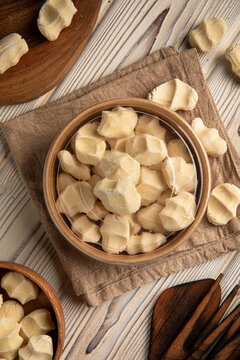 Traditional central asian dried salty sour milk cheese balls kurt in wooden bowl on rustic wooden table top view