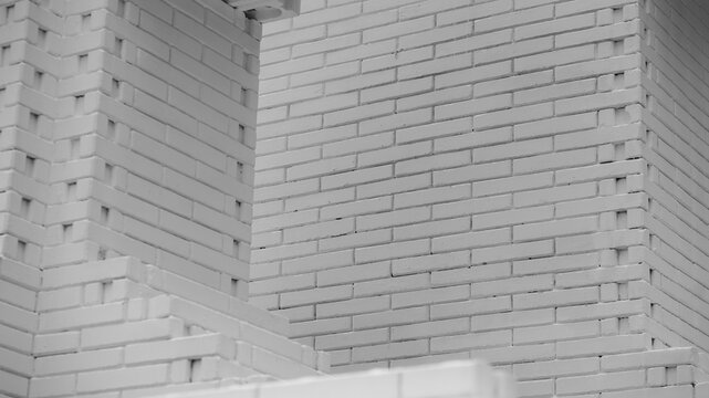 High-angle abstract shot of a clean white brick building wall featuring modern geometric construction details and layered masonry texture.