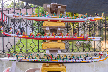 Handcrafted miniature Pacu Jalur traditional rowing boats on display. The models show three tiers of detailed boats with small rowers, popular souvenirs from Riau, Indonesia © Abdul
