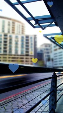 Animation of yellow and blue hearts floating over cityscape
