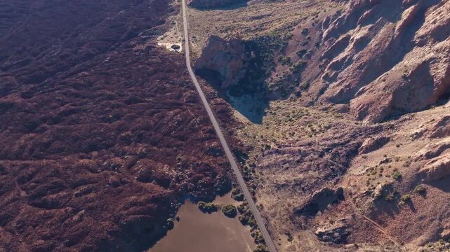 Aerial view of asphalt road winding through volcanic landscape in Teide national park Tenerife.