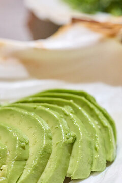 Rebanadas de aguacate fresco en plato blanco - Concepto de comida saludable, fotograf&iacute;a culinaria