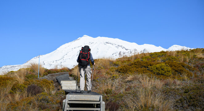 Hiking Tama Lakes track in winter. Snow-capped Mt Ruapehu in the distance. Tongariro National Park. New Zealand.