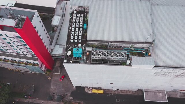 Aerial view of data center rooftop equipped with heavy-duty cooling units, industrial ventilation fans, condenser systems, and pipes for temperature control. Ideal for commercial technology, industria