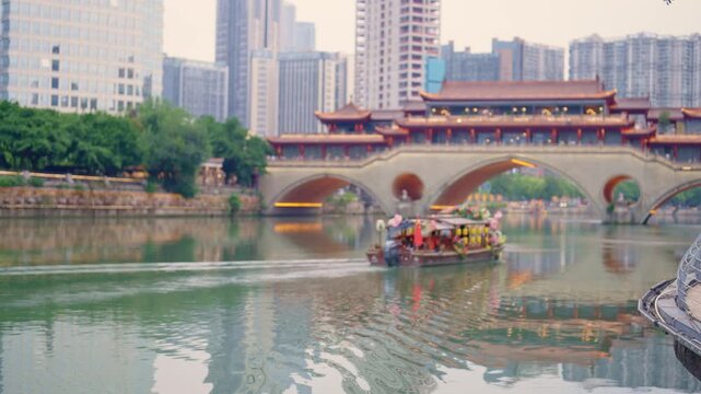 Chengdu Jinjiang Cruise, tourists admiring Anshun Lang Bridge in daytime. Traveling in China, enjoy Asian culture and history, must-visit tourist attraction, showcasing city iconic skyline by boat