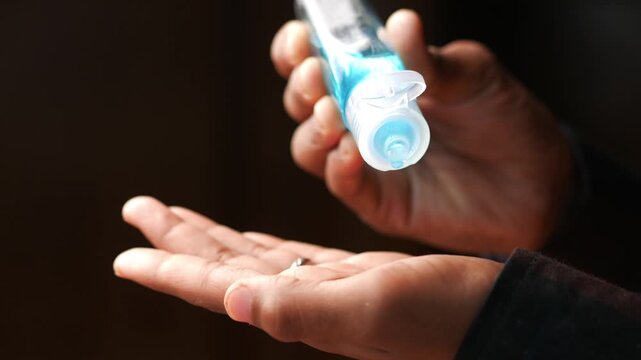 Hand sanitizer gel being dispensed onto open palm close up motion