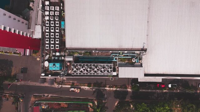 Aerial view of data center rooftop equipped with heavy-duty cooling units, industrial ventilation fans, condenser systems, and pipes for temperature control. Ideal for commercial technology, industria