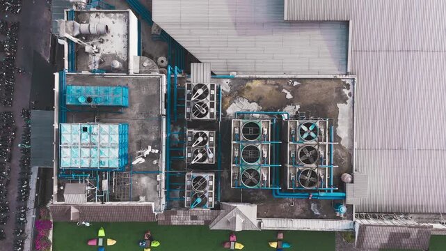 Aerial view of data center rooftop equipped with heavy-duty cooling units, industrial ventilation fans, condenser systems, and pipes for temperature control. Ideal for commercial technology, industria