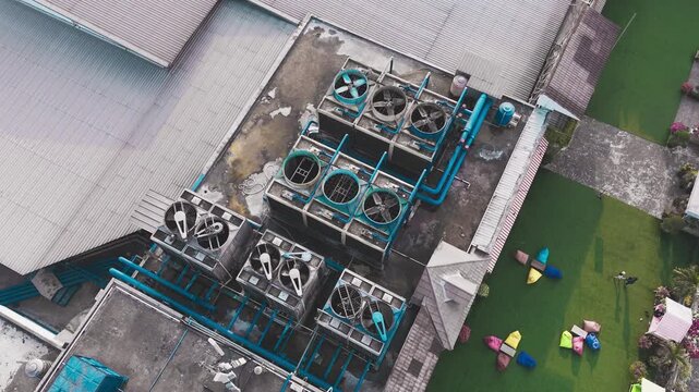 Aerial view of data center rooftop equipped with heavy-duty cooling units, industrial ventilation fans, condenser systems, and pipes for temperature control. Ideal for commercial technology, industria