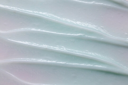 Face cream texture background. Green color skincare product smear smudge swatch.