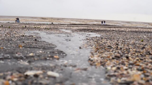 Stormwater Runoff Reaching the Ocean After Heavy Rain. A stream of rainwater reaches the ocean after heavy rainfall, illustrating monsoon runoff and coastal water movement.