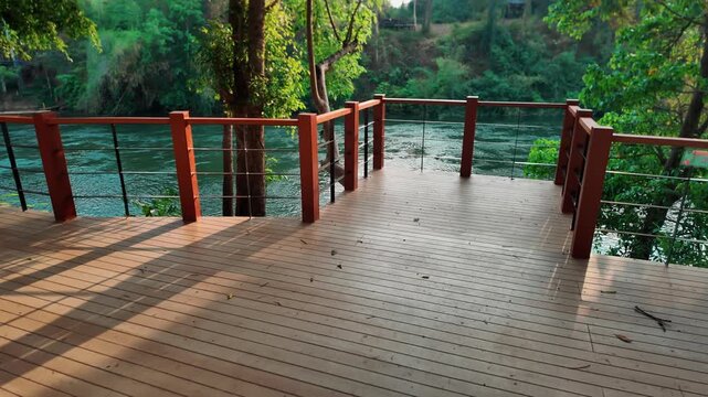 Waterfall view from railing over river in tropical jungle Sai Yok park, Scenic viewpoint with cascade and forest landscape in Thailand nature travel destination 4k