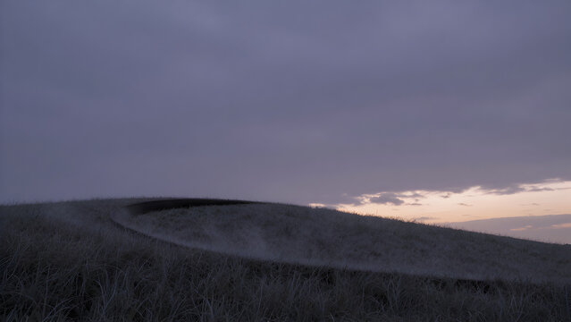 Dusk landscape over grassy rolling hills under cloudy sky