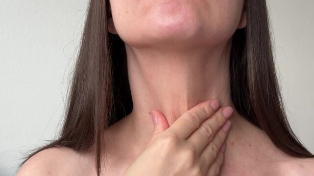 Young woman hands performing self massage on her neck. Beauty, health and anti-aging routine concept.
