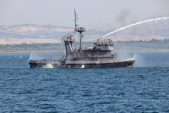 A fire ship extinguishes a fire on sea.