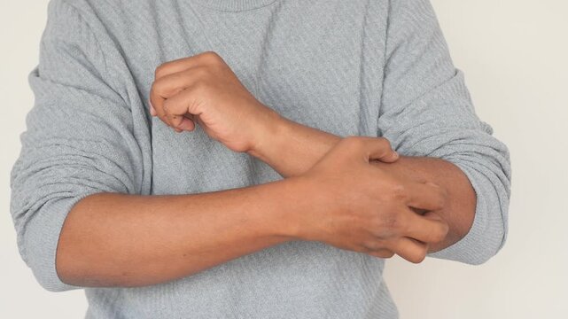Close up shot of person scratching arm due to itchiness motion