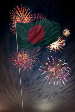 Waving National flag of Bangladesh and holiday fireworks in night sky