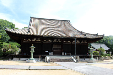 Fototapeta premium Hondo Main Hall and Lantern Courtyard at Taisanji Temple (the 52nd) on Shikoku Henro Pilgrimage, Matsuyama, Japan, July 2026