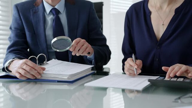 Business professional carefully examining a legal contract document with a magnifying glass in a meeting, conducting a thorough review and due diligence process with a colleague