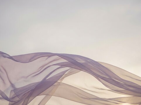 Semi-sheer lavender chiffon fabric billowed and floating weightlessly in gentle air