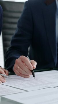 Business partners discussing contract terms, reviewing legal documents, strategizing agreement conditions, or finalizing a major transaction together
