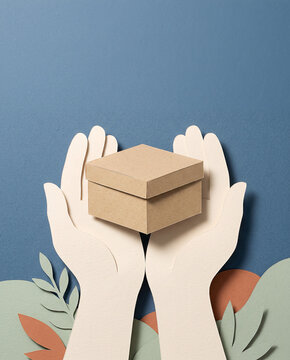 Papercraft two hands holding cardboard delivery box with leaves for eco friendly packaging concept