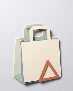 Papercraft shopping bags with red triangle logo for retail branding and commercial packaging concept