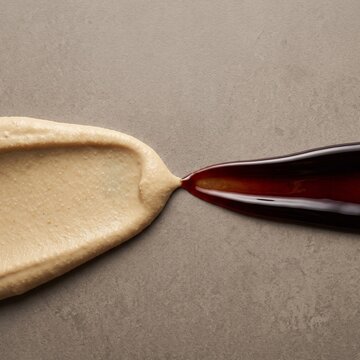 Tahini and pomegranate molasses contrast on stone