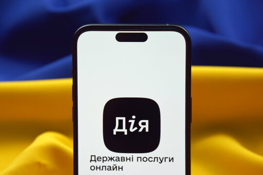 Diia application on the smartphone screen against the background of the flag of Ukraine.