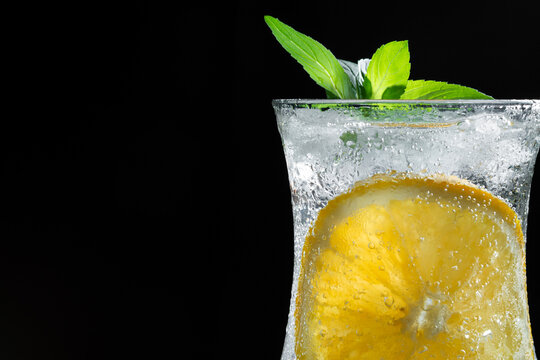 Refreshing Sparkling Citrus Drink With Orange Slice and Fresh Mint on Dark Wooden Background