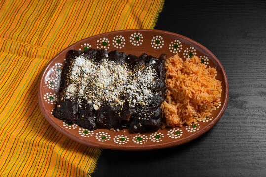 Traditional Mexican Enchiladas With Mole Sauce and Rice on Talavera Plate