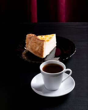 Coffee Cup with a Slice of Pie on a Dark Surface