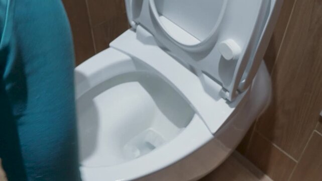 Modern white ceramic toilet bowl with open lid in a contemporary home bathroom.
