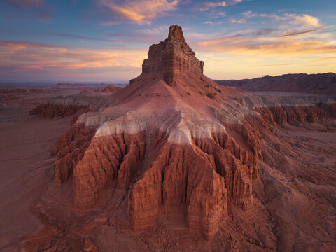 Aerial view of Goblin Valley State Park featuring unique red rock formations and eroded sandstone spires under a soft golden hour sky in Green River, Utah, United States.